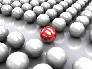 Set of glossy grey balls with red ball in the middle