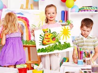 Child painting at easel.