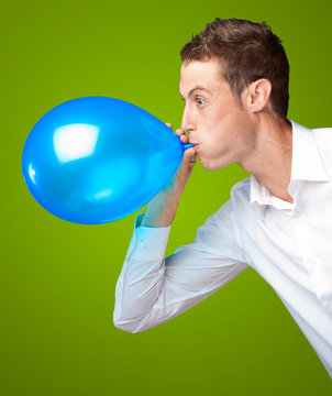 Portrait Of Young Man Blowing A Balloon