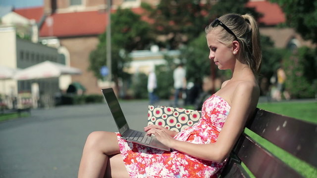 Attractive woman working on laptop in the city