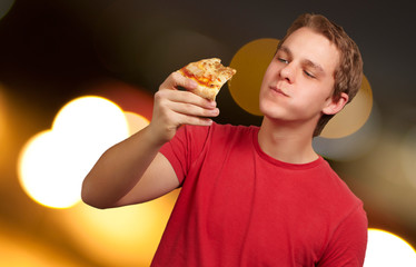 portrait of a young man eating pizza