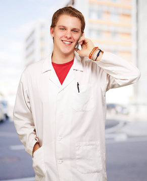 portrait of young academic talking on mobile against a modern bu