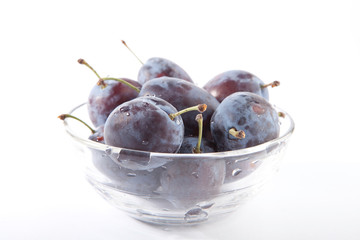 plums in glass bowl isolated on the white background