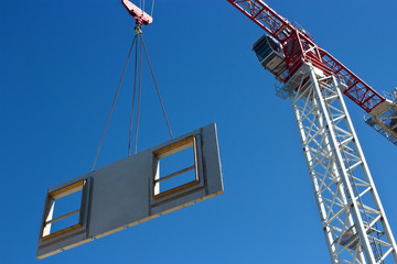 Tower crane is lifting preacast concrete panel - 44197488