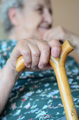 hand of a senior person holding wooden cane