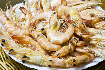 Close up boiled shrimp with shell on plate and basket