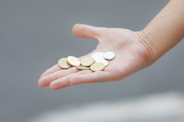Woman holding golden and silvery coins (shekels) in her hand