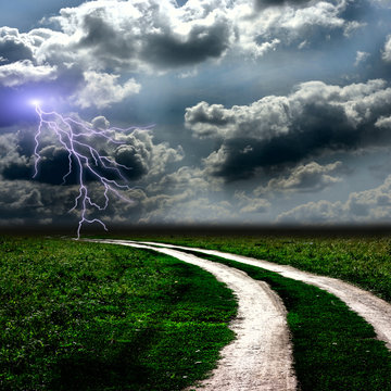 The road through  meadow and the stormy sky