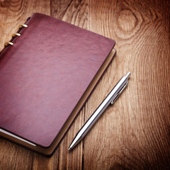 notebook and pen on wood background