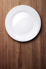 Empty white plate on wooden table