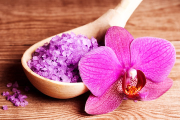 Fototapeta na wymiar sól do kąpieli w łyżce i kwiatów orchidei