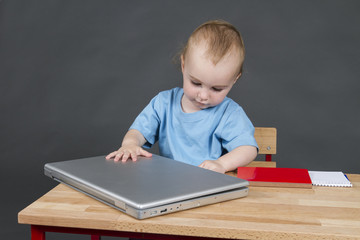 baby with laptop computer in grey background