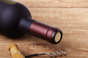 corkscrew and bottle of wine on the board