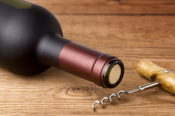 corkscrew and bottle of wine on the board
