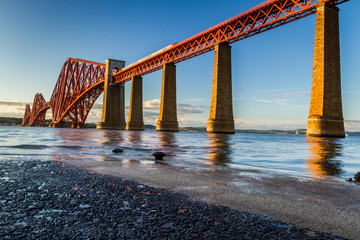 Train riding on the Forth Road Bridge at sunset