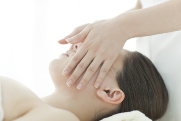 顔をマッサージするエステティシャン