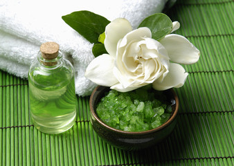 gardenia flower with towel with essential oil on green mat