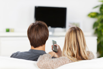 paar schaut auf fernseh-bildschirm