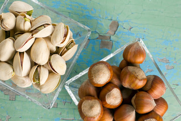 Pistachios and hazelnuts on the vintage wooden surface.