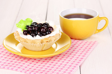 sweet cake with cup of tea on wooden background