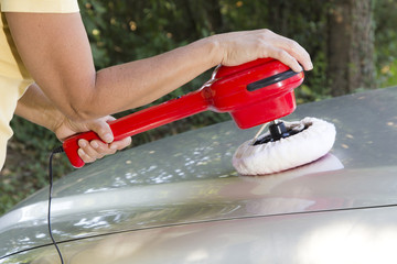 Polishing the car with electric polishing tool