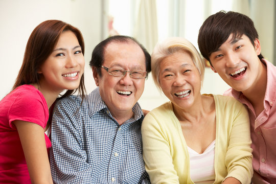 Portrait Of Chinese Parents With Adult Children Relaxing At Home