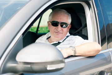 Handsome middle-aged man driving a modern car