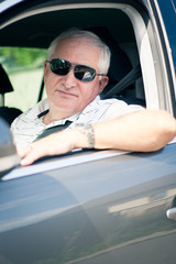 Naklejka premium Handsome middle-aged man driving a modern car