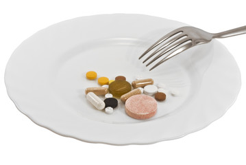 Pills on a plate with a fork