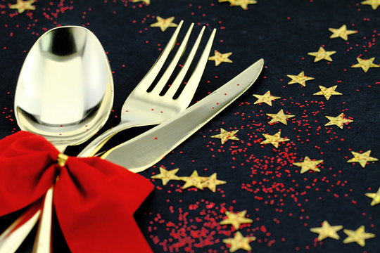 Spoon, fork and knife stacked up on a starry background