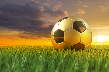 Fussball gold schwarz 3D auf Rasen im Sonnenuntergang
