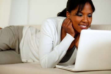 Naklejka premium Afro-american young woman reading on laptop screen