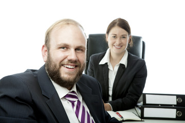 beard business man brunette woman at desk smiling