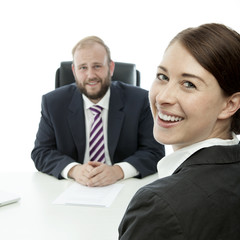 beard business man brunette woman at desk smile