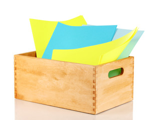 Wooden crate with colorful papers isolated on white