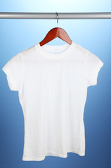 White t-shirt on hanger on blue background