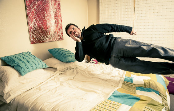 Man Thinking While Levitating Over Bed