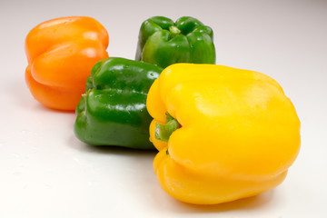 Green, red and yellow pepper isolated on white
