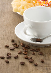 empty cup of coffee with beans on wood