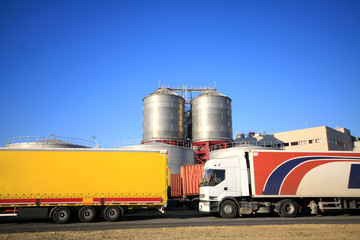 Steel industrial tanks behind of tractor trailer trucks