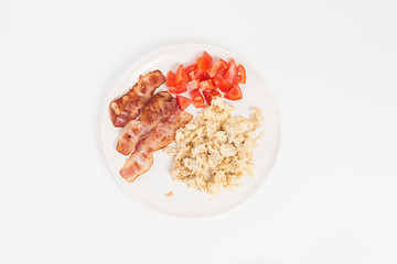 fried eggs, bacon and vegetables on white background