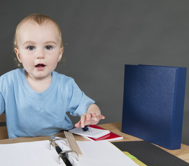 child with paperwork at small desk