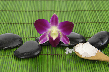 orchid with zen stone and sea salt in spoon on mat