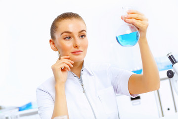 Fototapeta premium Young female scientist working in laboratory