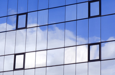 Sky and clouds reflected in a modern building glass facade