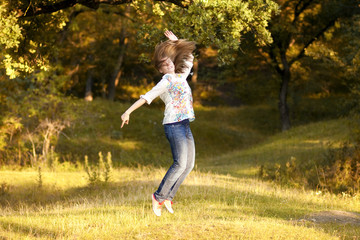Young pretty woman jumping in the autumn park