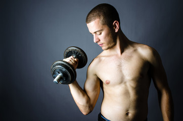 Fototapeta na wymiar Handsome man lifting weights