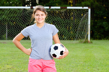 Portrait of teen girl soccer player on field