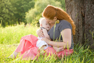 Happy mother and baby with Down syndrome hugging and kissing