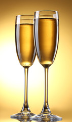 glasses of champagne on yellow background